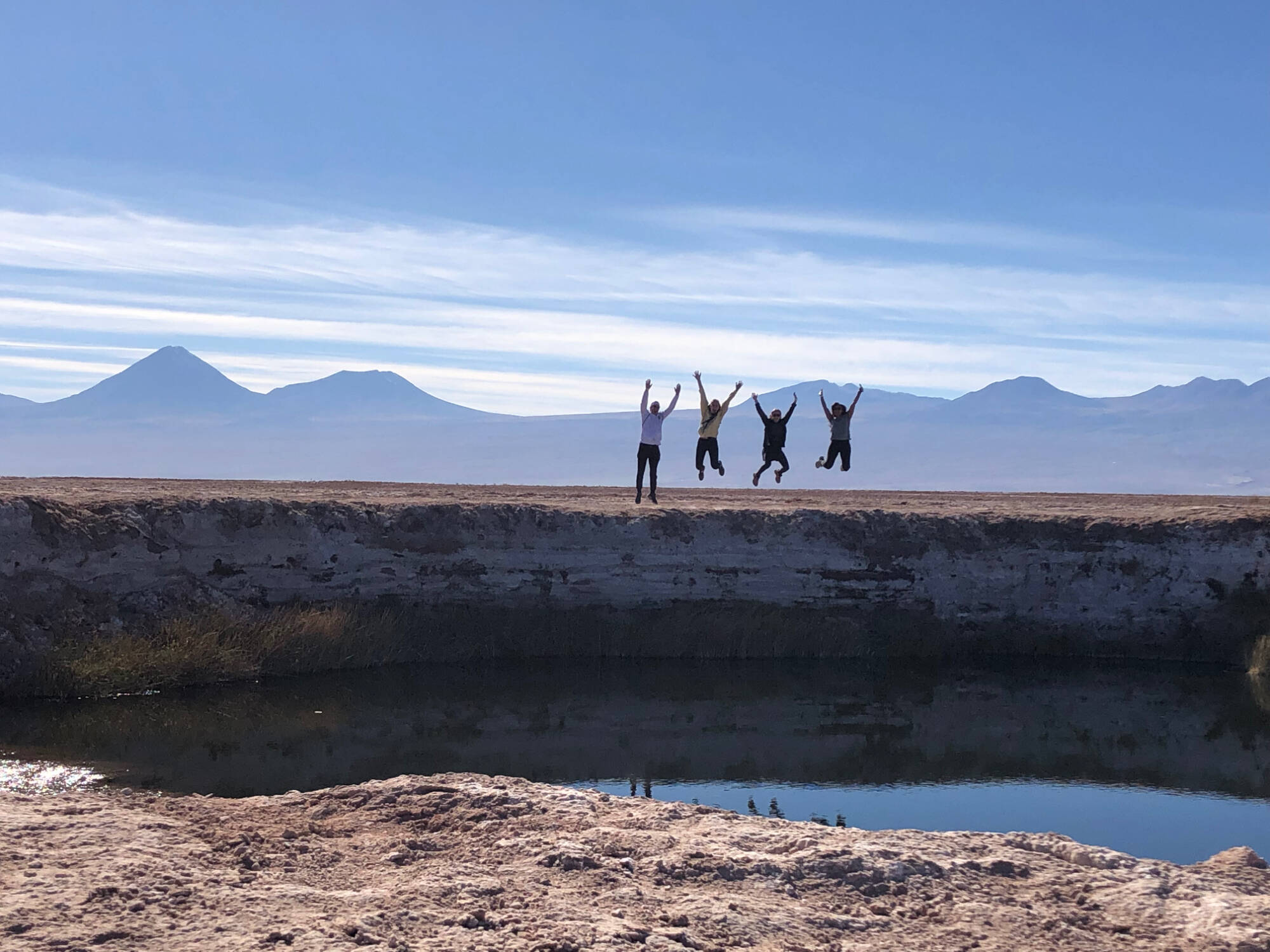 Students jumping with mountains in the background in Chile